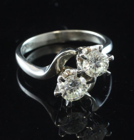 An 18ct white gold and two stone diamond crossover ring, size O.